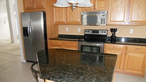 A kitchen with wooden cabinets, stainless steel appliances, and a granite countertop. - "Luxury Villa in Punta Gorda, FL - 4BD/3BA, Pool, Jacuzzi" Sandhill Cranes. (Punta Gorda)