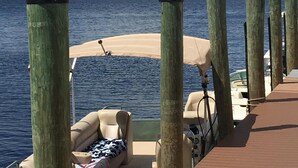 A boat deck with a covered seating area, wooden posts, and a view of the water and sky. - "Luxury Villa in Punta Gorda, FL - 4BD/3BA, Pool, Jacuzzi" Sandhill Cranes. (Punta Gorda)