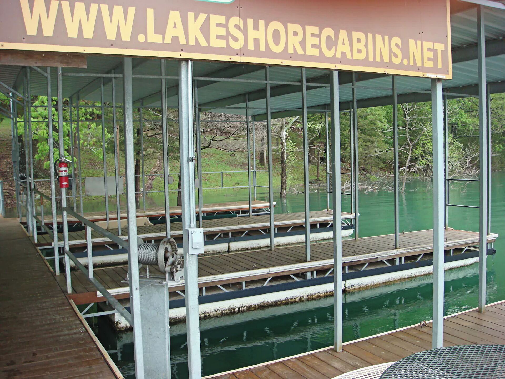 A covered dock area with picnic tables and a fire extinguisher.