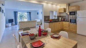 A modern kitchen with wooden cabinets, a built-in oven, and a refrigerator. - Domaine Ghjulia - Casa Nebbiu (Patrimonio)
