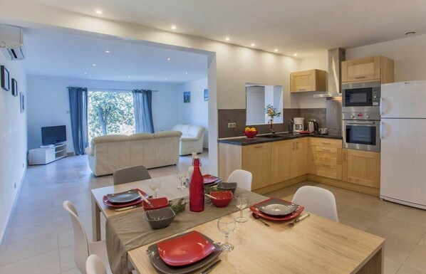 A modern kitchen with wooden cabinets, a built-in oven, and a refrigerator.