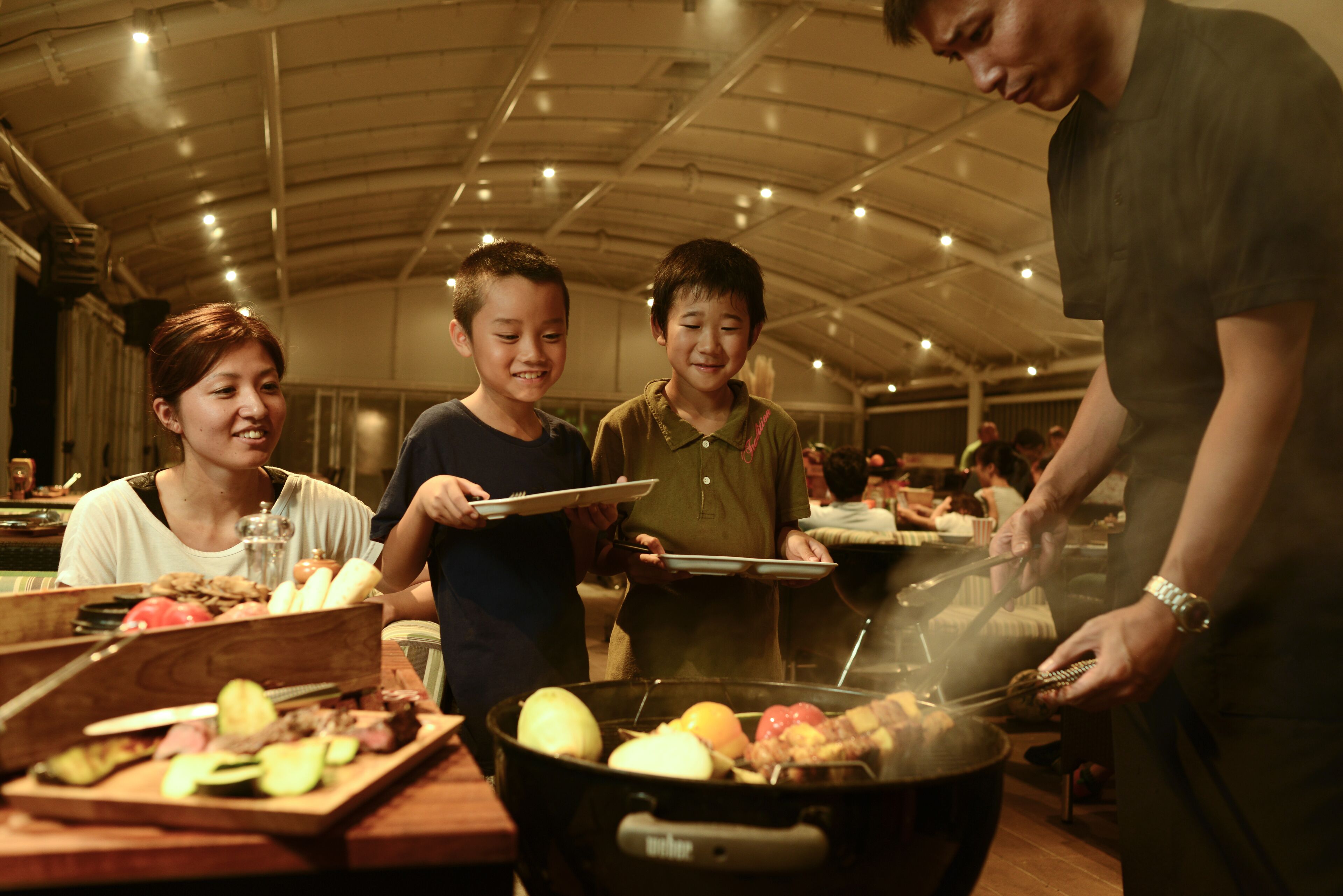 A group of people dining in a spacious, well-lit indoor setting with a high ceiling and modern design.