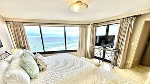 A hotel room with a large bed, a TV, and a view of the ocean. - Gorgeous beach views! Private sun deck! 4133 BS1 (Miramar Beach)