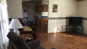Un salon avec un canapé, une table basse, une lampe et un téléviseur.