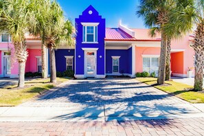 Una hilera de edificios coloridos con un paseo pavimentado al frente.
