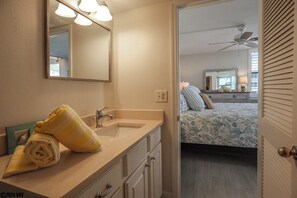 A bathroom with a sink, mirror, and towel.