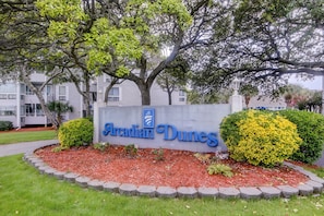Un panneau indiquant « Arcadian Dunes », avec un jardin aménagé devant.