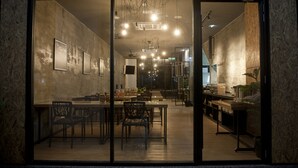 Un espace de restauration moderne doté d’une cloison en verre, d’un plancher en bois et d’un éclairage contemporain.