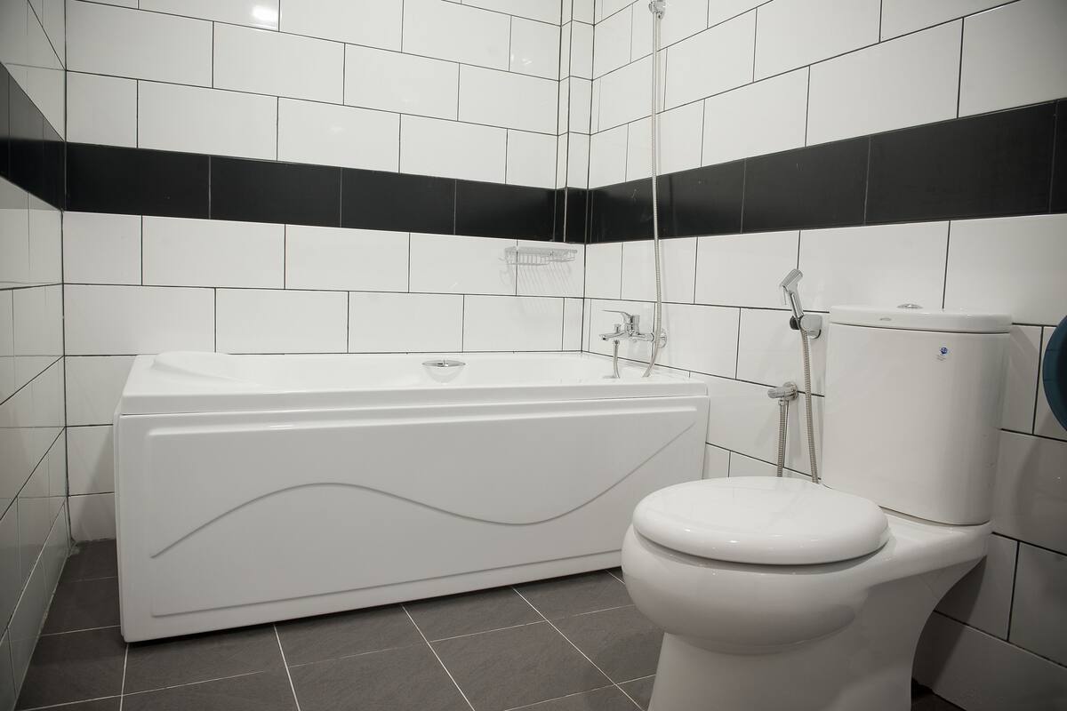 A bathroom with a bathtub, toilet, and shower.