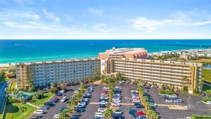 Um hotel com vários andares, estacionamento e vista para o oceano.