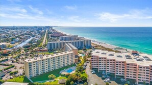 Um hotel à beira-mar com vários edifícios, uma praia e um porto de iates.