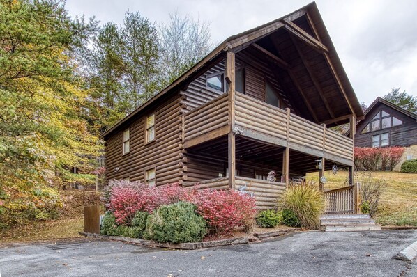 A log cabin with a porch, surrounded by autumn foliage. - ER13 - Moose Manor  Great location - Close to town! (Pigeon Forge)