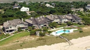 An aerial view of a residential area with multiple houses, a swimming pool, and a beach. - Happy Days Luxury Oceanfront Beach Villa in DeBordieu (Georgetown)