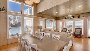 A spacious room with wooden walls, a large dining table with white chairs, a sofa, and a chair. - Gulf views from rooftop deck, 2 heated community pools, gated community! (Port Aransas)