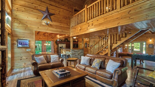 A spacious log cabin interior with a living room, kitchen, and a loft area. - Family Fun | Theater, Gameroom, Hot Tub (Gatlinburg)