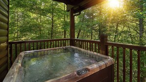 A hot tub on a wooden deck with a forest view. - Family Fun | Theater, Gameroom, Hot Tub (Gatlinburg)