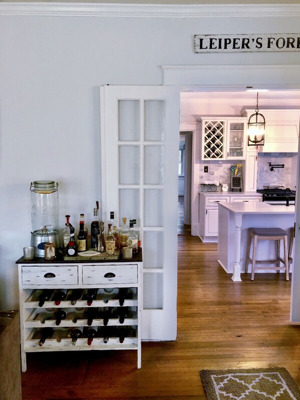 A kitchen with a wine rack, a sign reading 'LEIPER'S FOR', and a hanging light fixture.