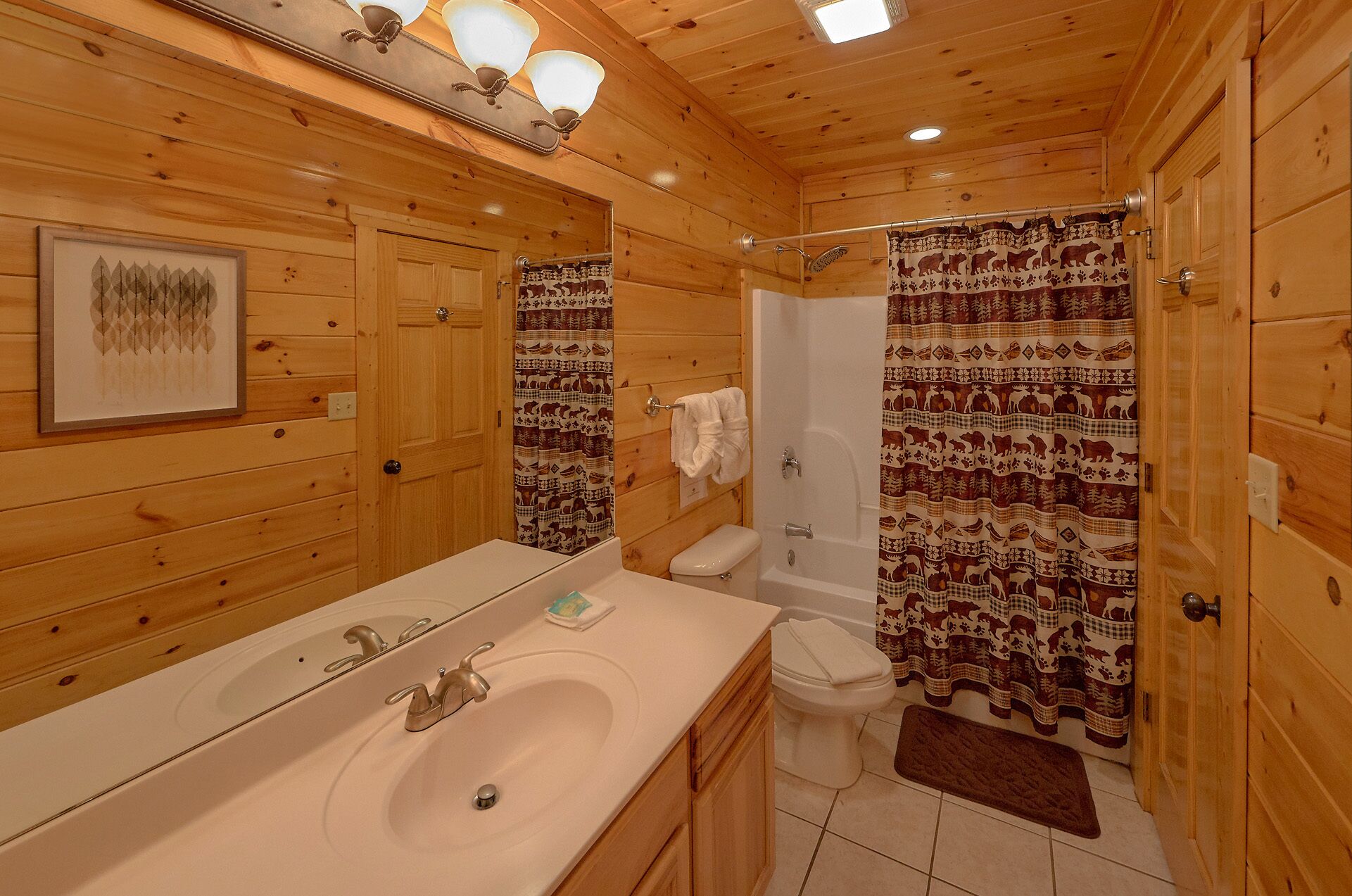 Une salle de bain rustique, aménagée dans une cabane en bois, avec un lavabo, des toilettes et une douche.