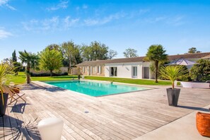 A swimming pool with a wooden deck, a stone building, and a well-maintained lawn. - Homerez - Villa in Saint-Germain-d'Esteuil (Saint-Germain-d'Esteuil)
