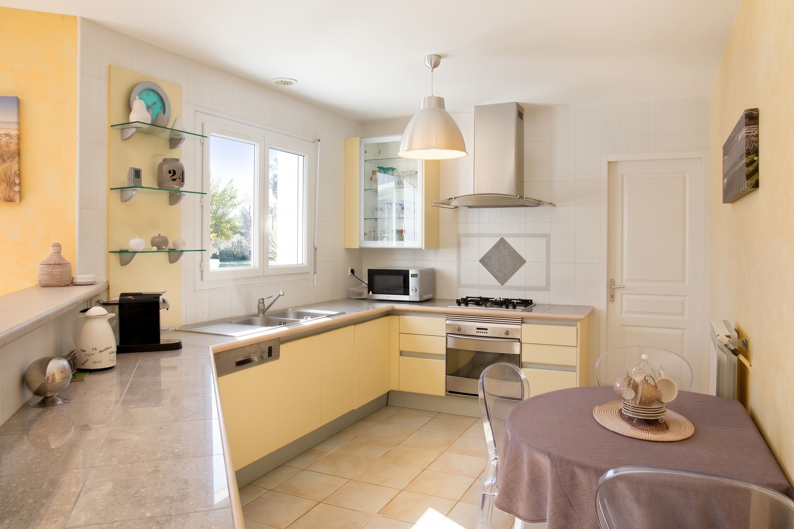 Une cuisine compacte équipée d’un four à micro-ondes, d’une cuisinière et d’un petit coin repas avec une table et des chaises.