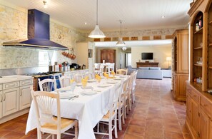 A spacious kitchen with a dining area set for a meal. - Homerez - Villa in Saint-Germain-d'Esteuil (Saint-Germain-d'Esteuil)
