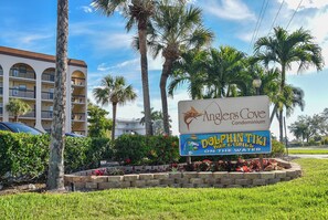 En skylt för Anglers Cove, ett bostadskomplex, med en bar och restaurang vid vattnet som heter Dolphin Tiki Bar & Grill.