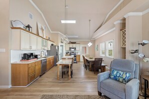 A spacious kitchen with wooden cabinets, a dining area with a table and chairs, and a seating area with a sofa and armchair.