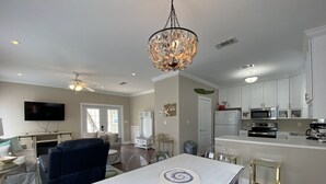 A modern kitchen with white cabinets, a stainless steel refrigerator, and a microwave. - Luxury Condo Boasting Lagoon Oasis Pool Near White Sandy Beaches (Pensacola)