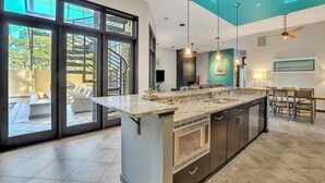 A modern kitchen with a large island, built-in appliances, and a view to an outdoor patio. - 17 Firethorn - HGTV "Wow-Worthy", Pool, Fire Pit (Hilton Head Island)
