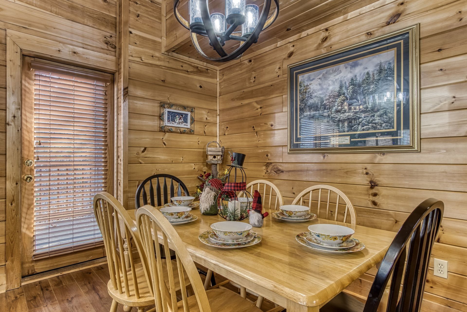 Ein Esszimmer aus Holz mit einem großen Tisch, gedeckt für sechs Personen, umgeben von Stühlen.