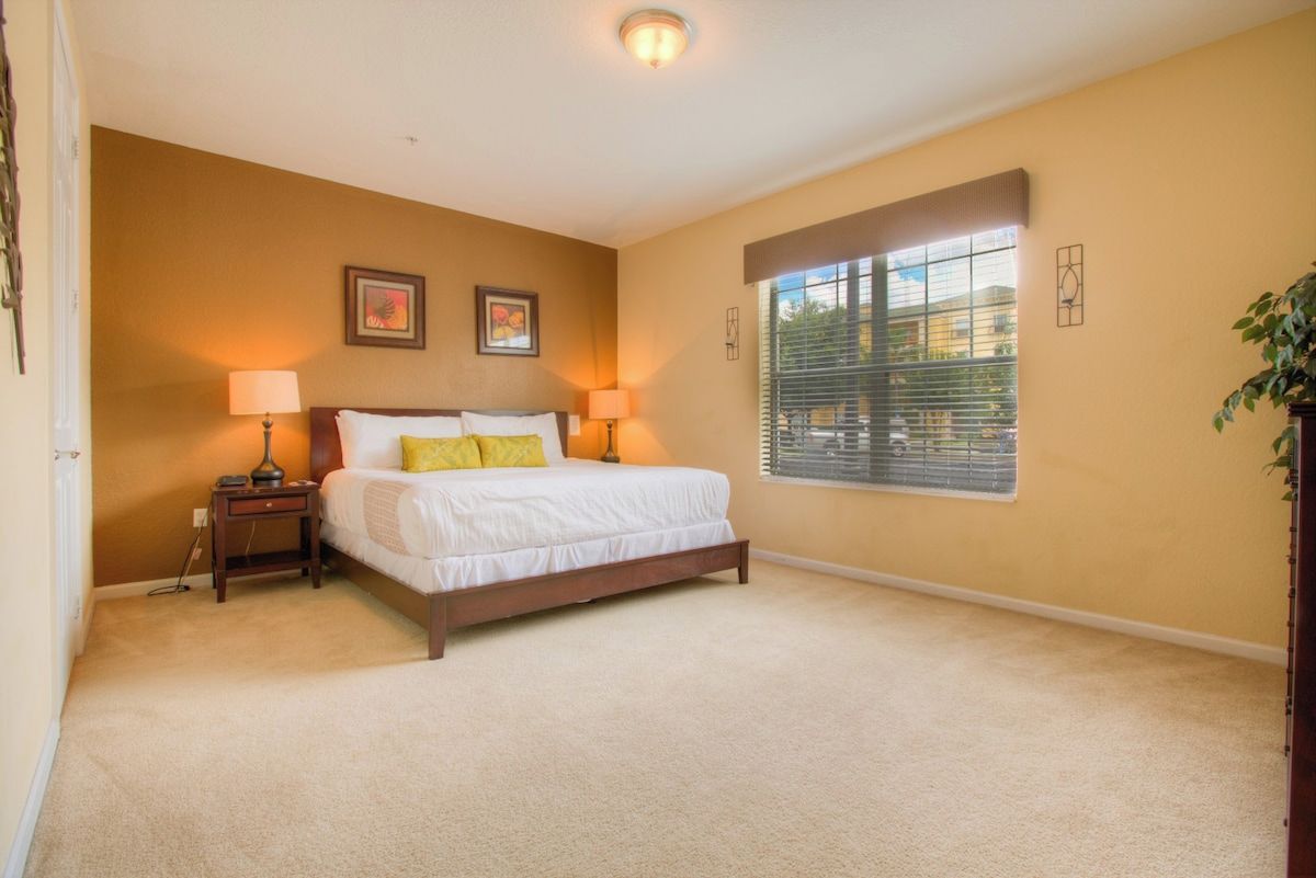 Exclusive bedroom of the condo in Orlando - It offers a cozy king size with with neat and clean linen and fluffy pillows - Enjoy restful nights in a relaxing and lavish ambiance - Thoughtfully appointed bedside window with outside views