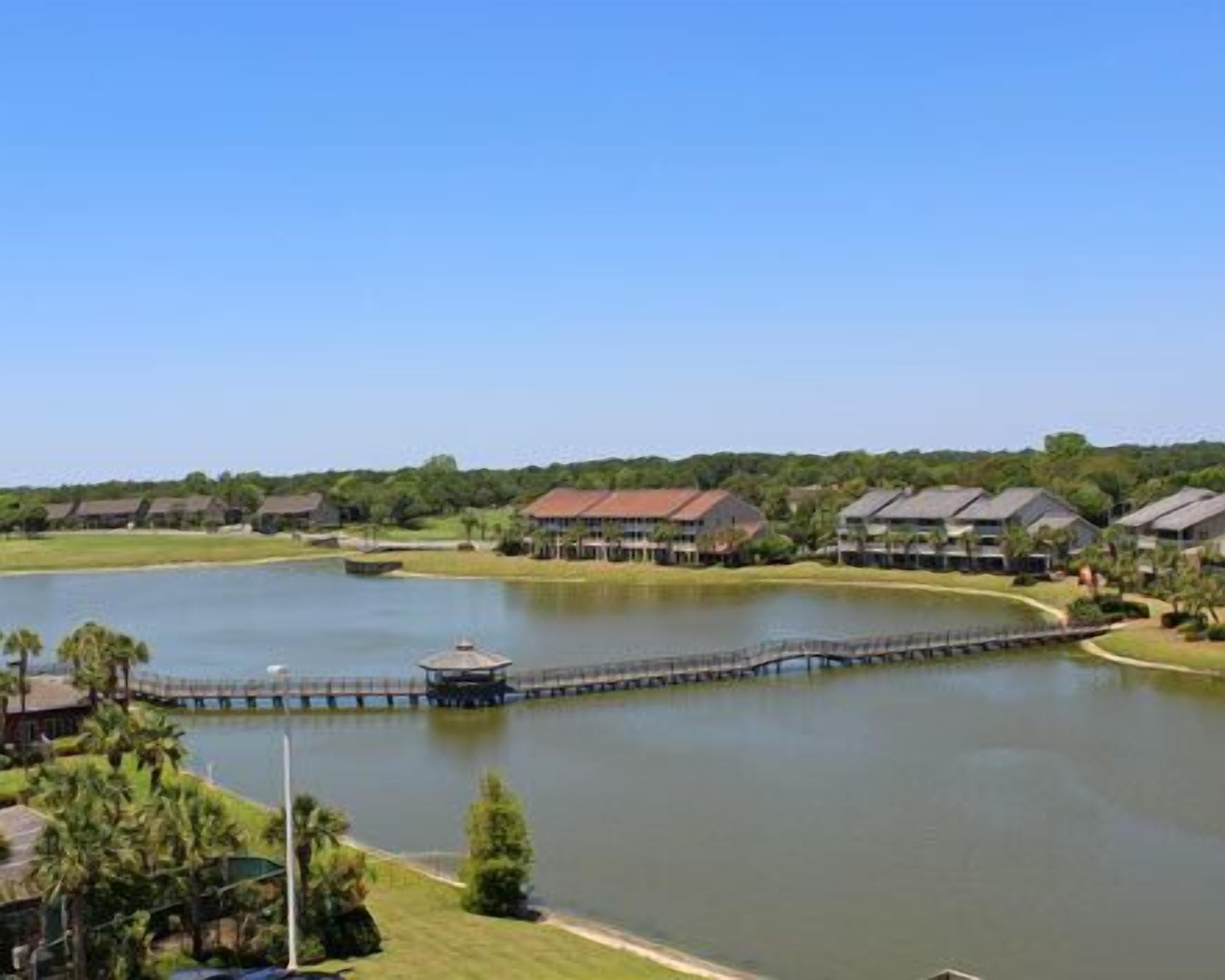 A lakeside view of a resort with a dock, a gazebo, and multiple buildings.