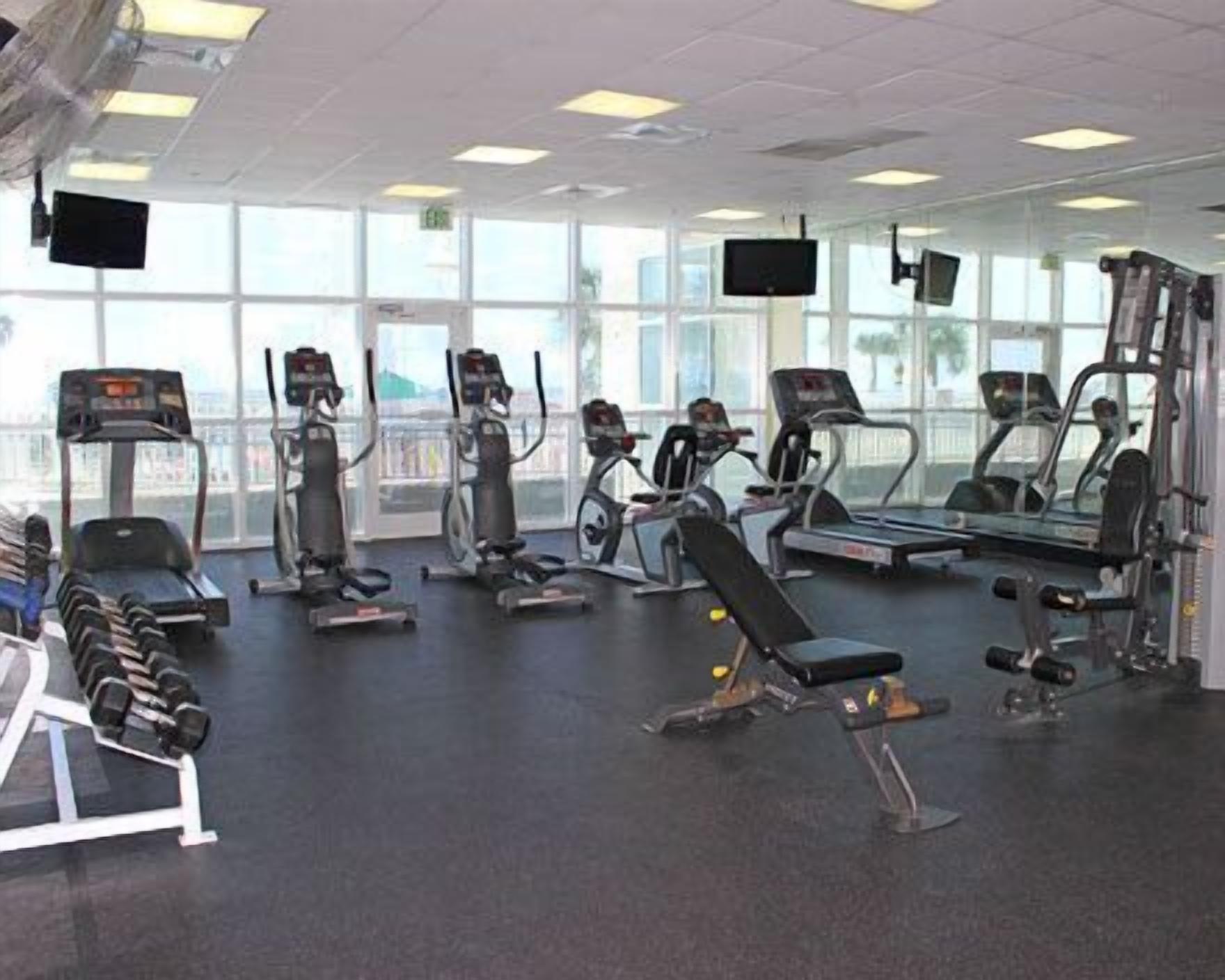 A gym with treadmills, elliptical machines, and weight benches.
