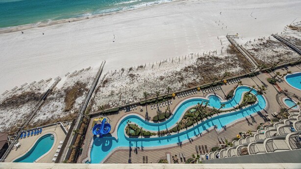 Un complexe hôtelier doté d’une grande piscine, d’une plage et d’une tour de surveillance pour les sauveteurs.