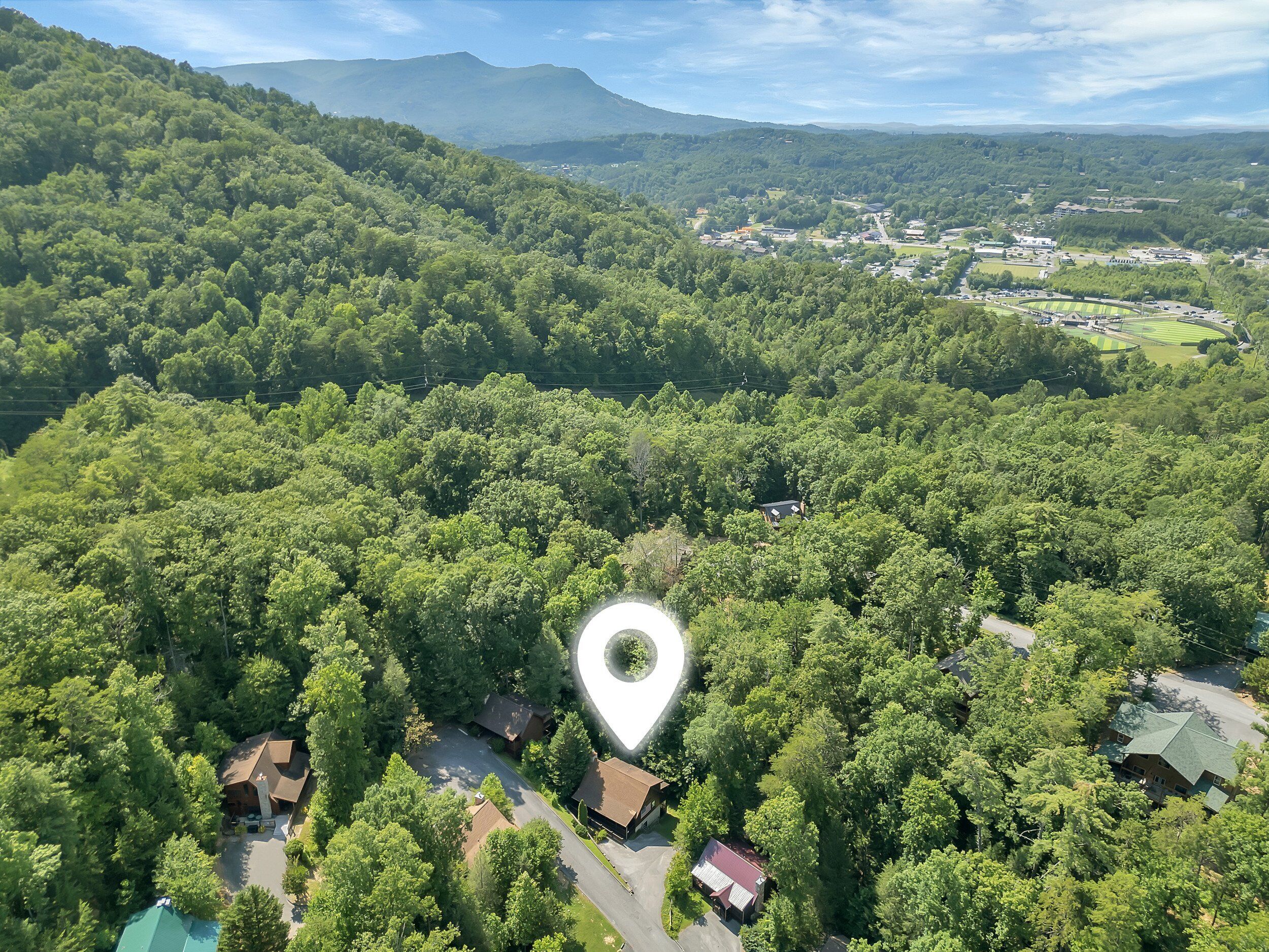 An aerial view of a residential area with a prominent white pin indicating a location.