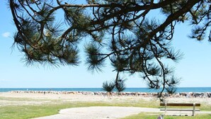 A paved path leading to a bench by a beach with a clear sky. - Cozy 2-Room House with Mezzanine, Pool & Parking - Saint-Cyprien Beach (Saint-Cyprien)