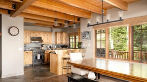Una cocina moderna con armarios de madera, una isla central y una zona de comedor con banco.