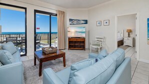 A room with a sofa, a table with a basket, a TV, a chair, and a painting. - Beach Vibes Ground Floor! 3 BR 3 BATH!!! Phoenix X 117 (Orange Beach)