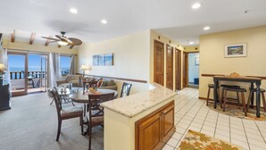 Amplia sala de estar con mesa de comedor, sillas y mostrador de cocina.