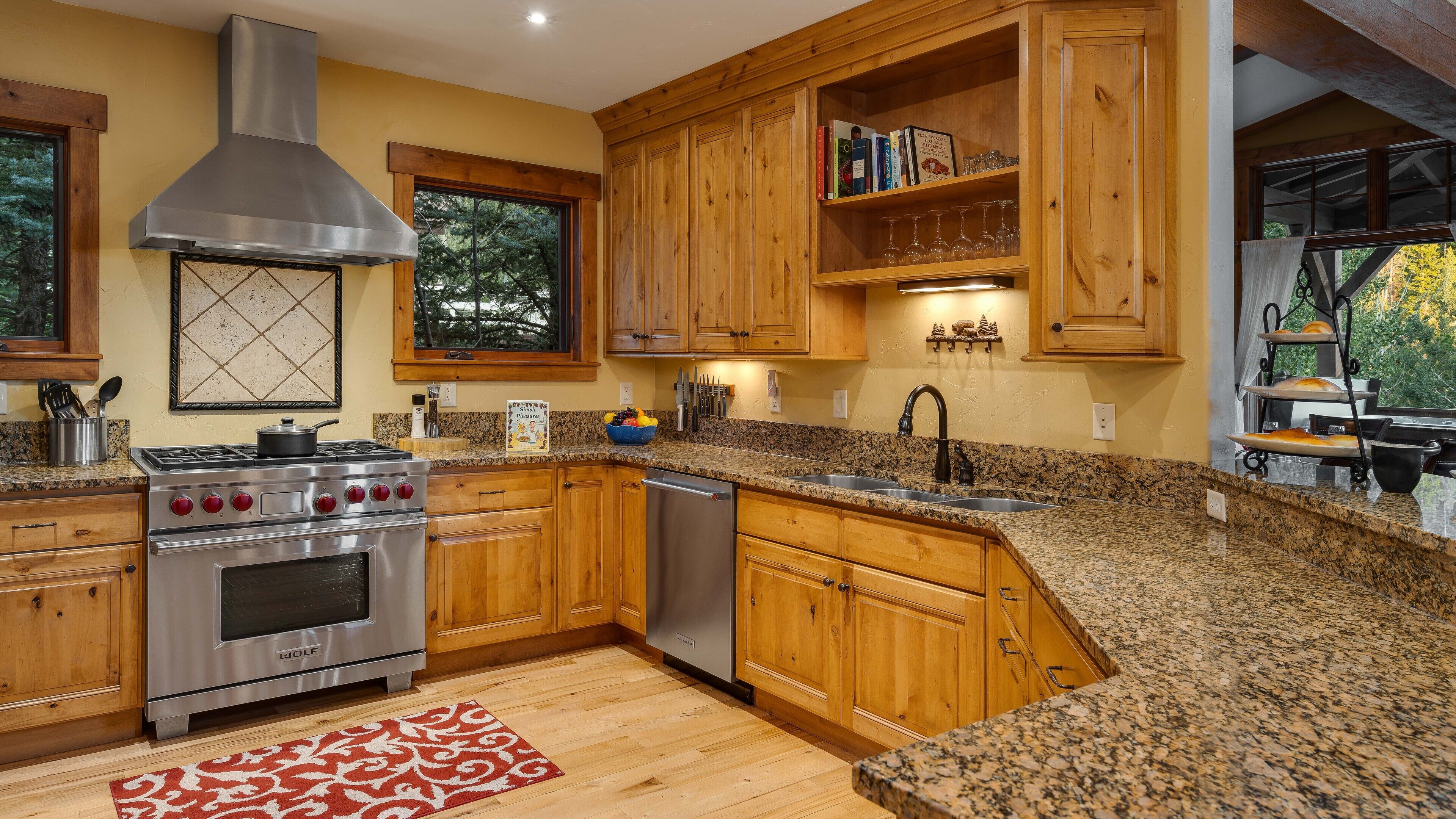A kitchen with wooden cabinets, a stainless steel stove, and granite countertops.