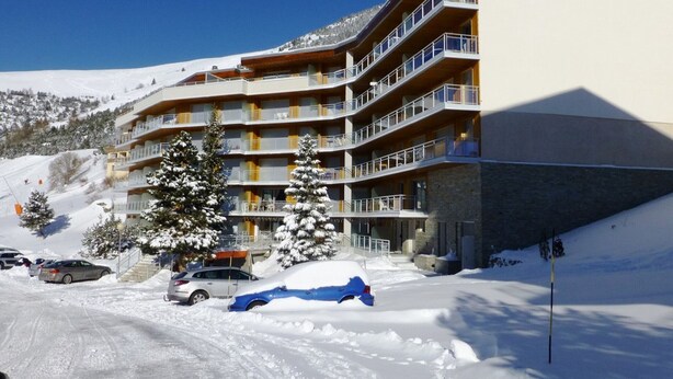 A multi-story hotel with balconies, situated in a snowy mountainous area. - Spacious 4-Room Apartment for 9 - Ski Lift, Balcony, Garage - Alpe d'Huez (Huez)