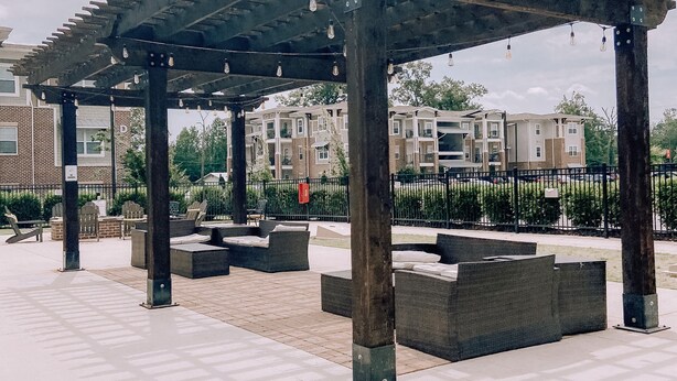 A covered outdoor seating area with benches and a pergola structure.