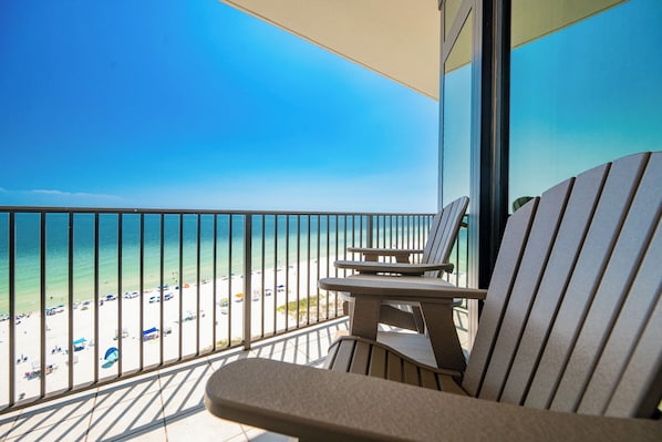 A balcony with a view of a beach and ocean.