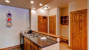 Una cocina con encimeras de granito, armarios de madera e un lavamanos empotrado.