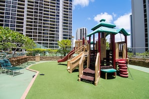 Explore the outdoor play area with a slide, climbing structure, and seating area.