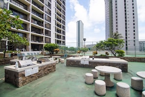 Guests can dine or relax in this outdoor patio area, featuring barbecue grill and comfortable seating.