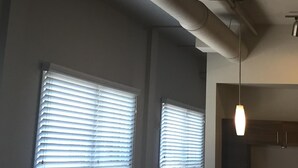 Habitación con techo que muestra conductos y una lámpara colgante.