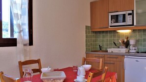 Una cocina compacta con gabinetes de madera, un microondas y una cafetera.