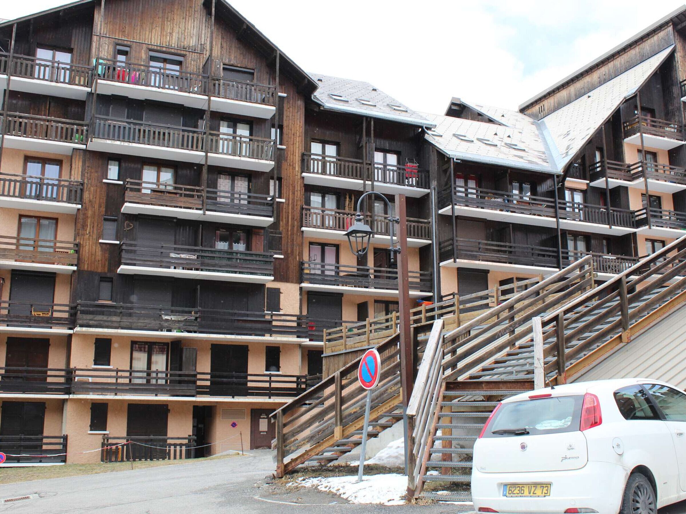 Un immeuble en bois à plusieurs étages, doté de balcons et d’un escalier menant aux étages supérieurs.