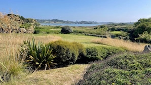 A coastal landscape with a clear view of the sea, grassy fields, and a distant town. - Renovated house with garden, wifi, BBQ, parking, 250m from the sea - Pleumeur-Bodou (Pleumeur-Bodou)